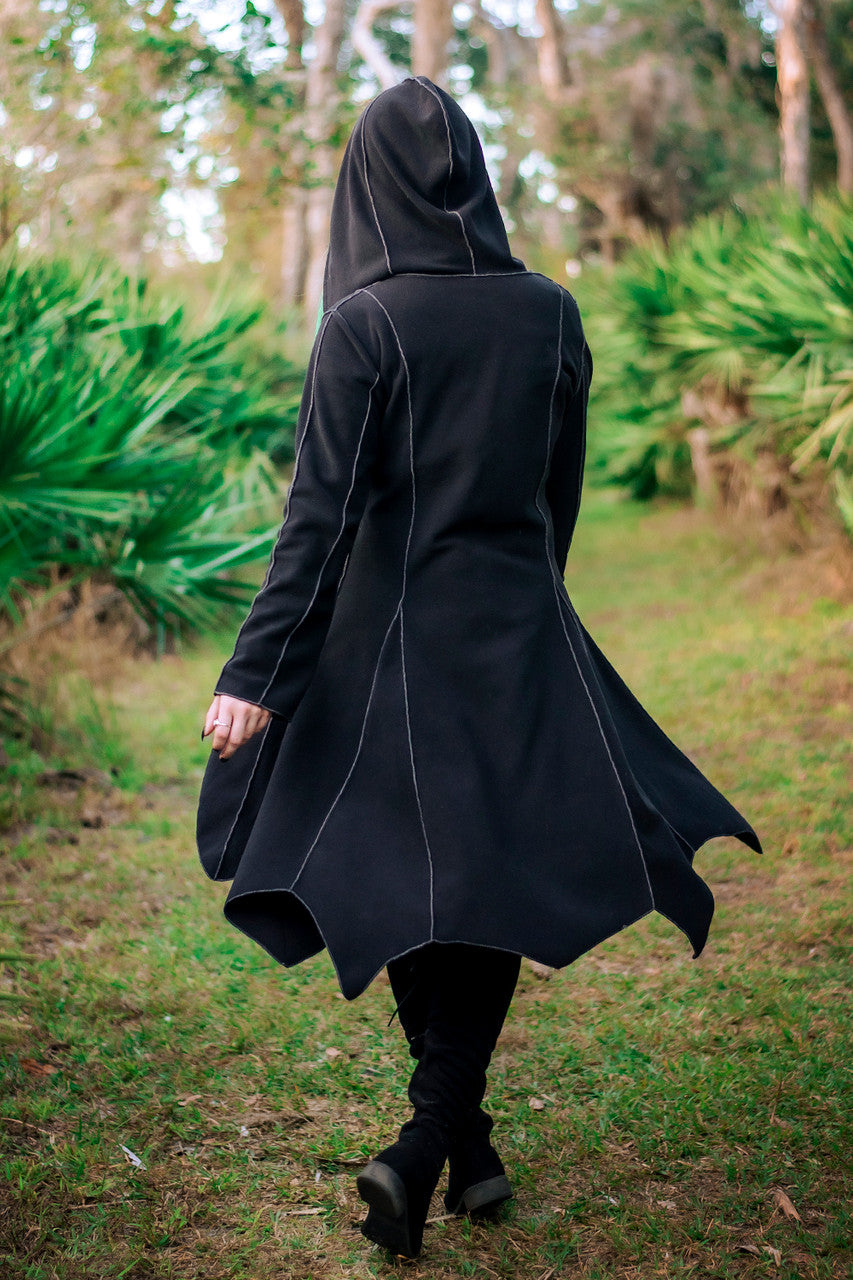 Conjurer's Coat in black hood up back angle and blowing in the wind.