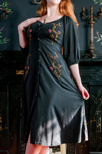 Model posing with one hand pulling out Persephone Summer Dress, and other hand resting on shoulder.