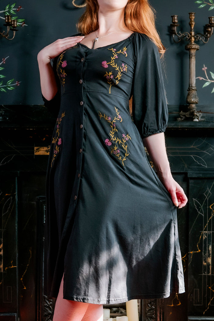 Model posing with one hand pulling out Persephone Summer Dress, and other hand resting on shoulder.