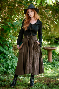 Forager Skirt in Olive Brown, front view with hands in pockets