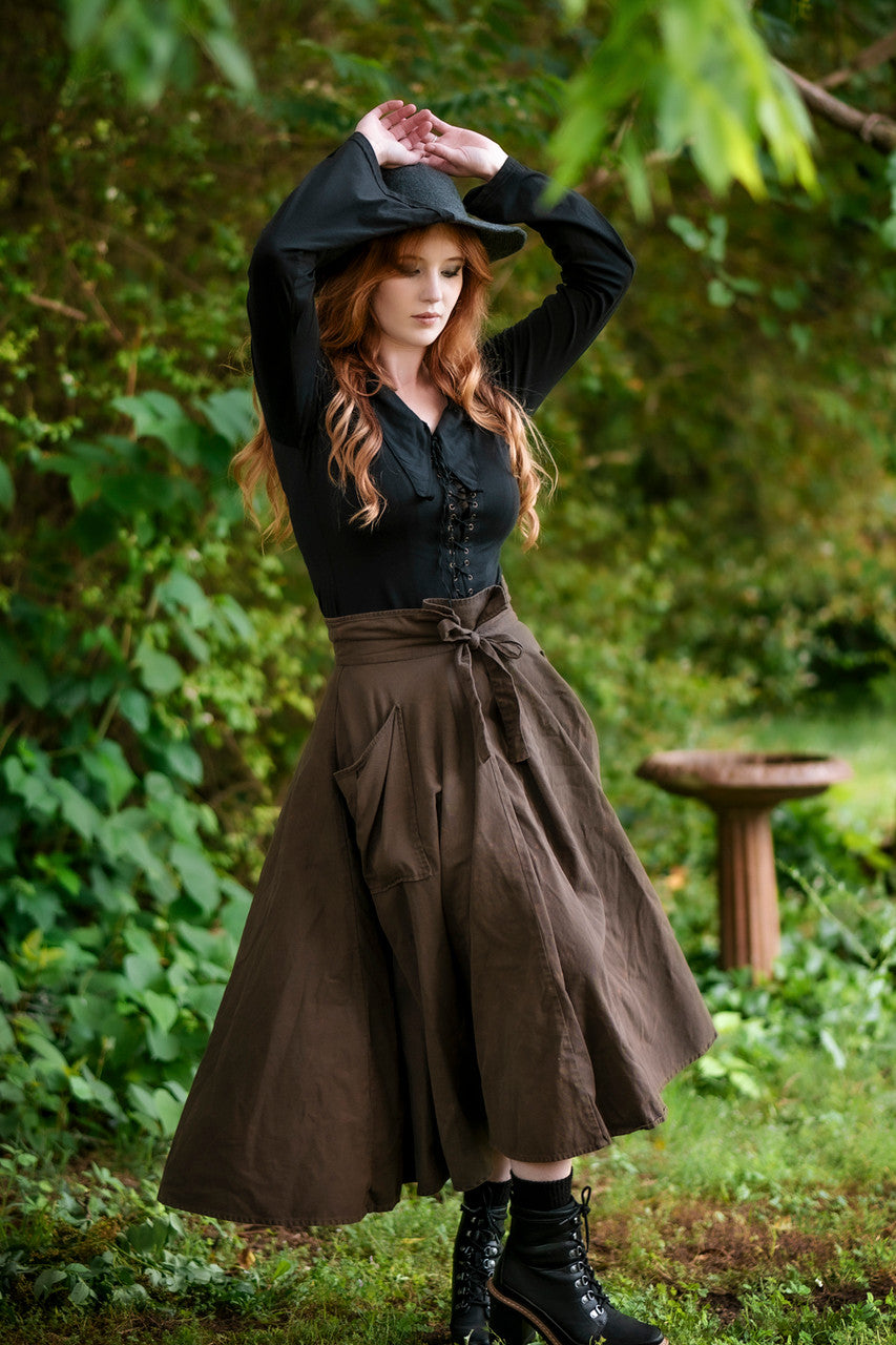 Forager Skirt in Olive Brown, front view with hands up and twirling