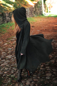 Conjurer's Coat in olive green open and blowing in the wind.