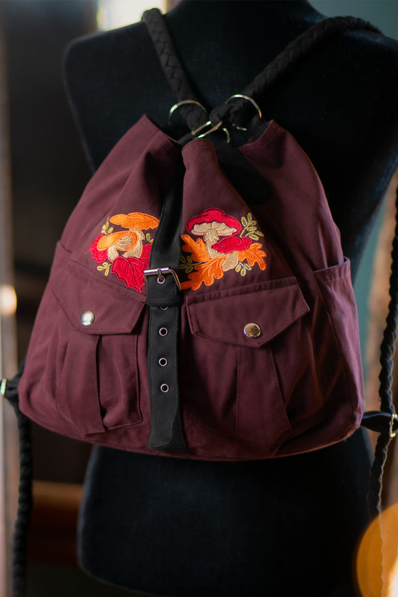 Mushroom Convertible Bag in Burgundy with Black straps, worn as a backpack
